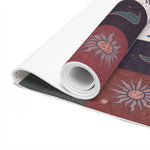 Close-up of rolled Cosmic Balance mat edge, detailed sun motif on rust tile, textured grey underside