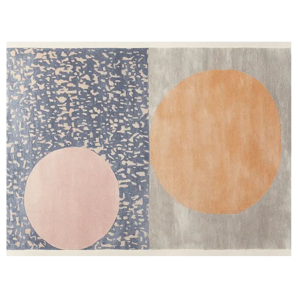 A contemporary hand-tufted wool area rug featuring an abstract design with two large circles in soft pastel colors, set against a textured blue and grey background, ideal for modern home decor.