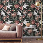White crane blooms wallpaper behind pink velvet sofa; cranes in flight over blush chrysanthemums on dark ground