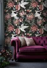 Dark moody room setting with purple Chesterfield sofa against crane and bloom wallpaper in deep botanical tones