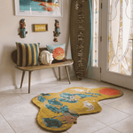 Decorative rug with animal design in a room with a bench, pillows, and surfboard.