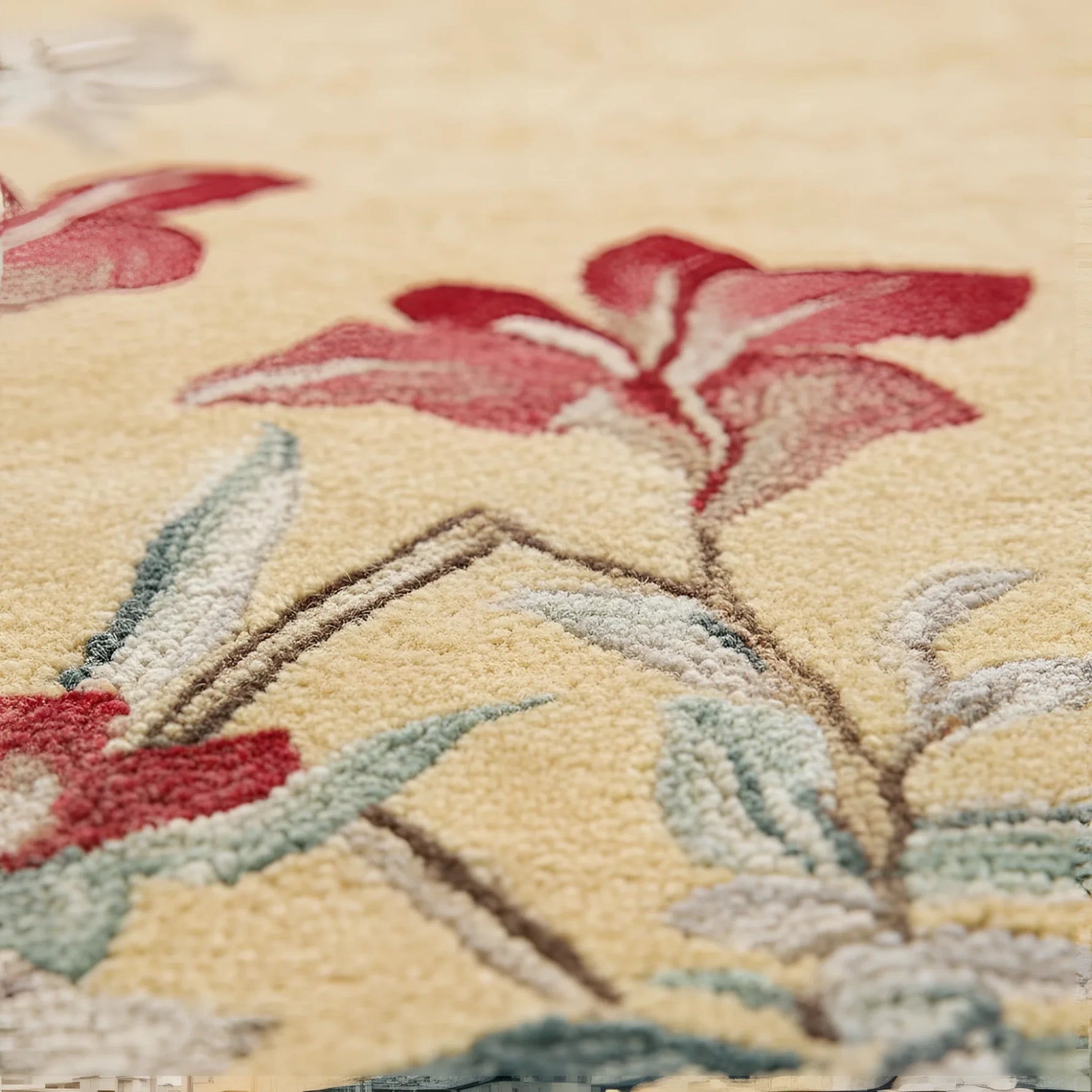 Close-up of a floral patterned rug with red flowers and green leaves on a beige background.