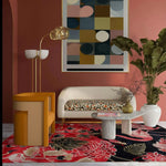 A vibrant living room featuring a Crimson Paradise Hand Tufted Area Rug with an abstract design in red and black hues. The wool rug adds a luxurious touch to the space, complementing the modern furniture and large wall art. Perfect for enhancing any living room area.