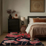 A cozy living room featuring a Crimson Paradise Hand Tufted Area Rug with vibrant red and pink flamingo designs, adding a splash of color to the neutral tones of the bedroom setting. This wool rug enhances the warm, inviting atmosphere, perfect for any living room area.