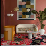 A vibrant living room featuring a Crimson Paradise Hand Tufted Area Rug with an abstract design in red and black hues. The wool rug adds a luxurious touch to the space, complementing the modern furniture and large wall art. Perfect for enhancing any living room area.