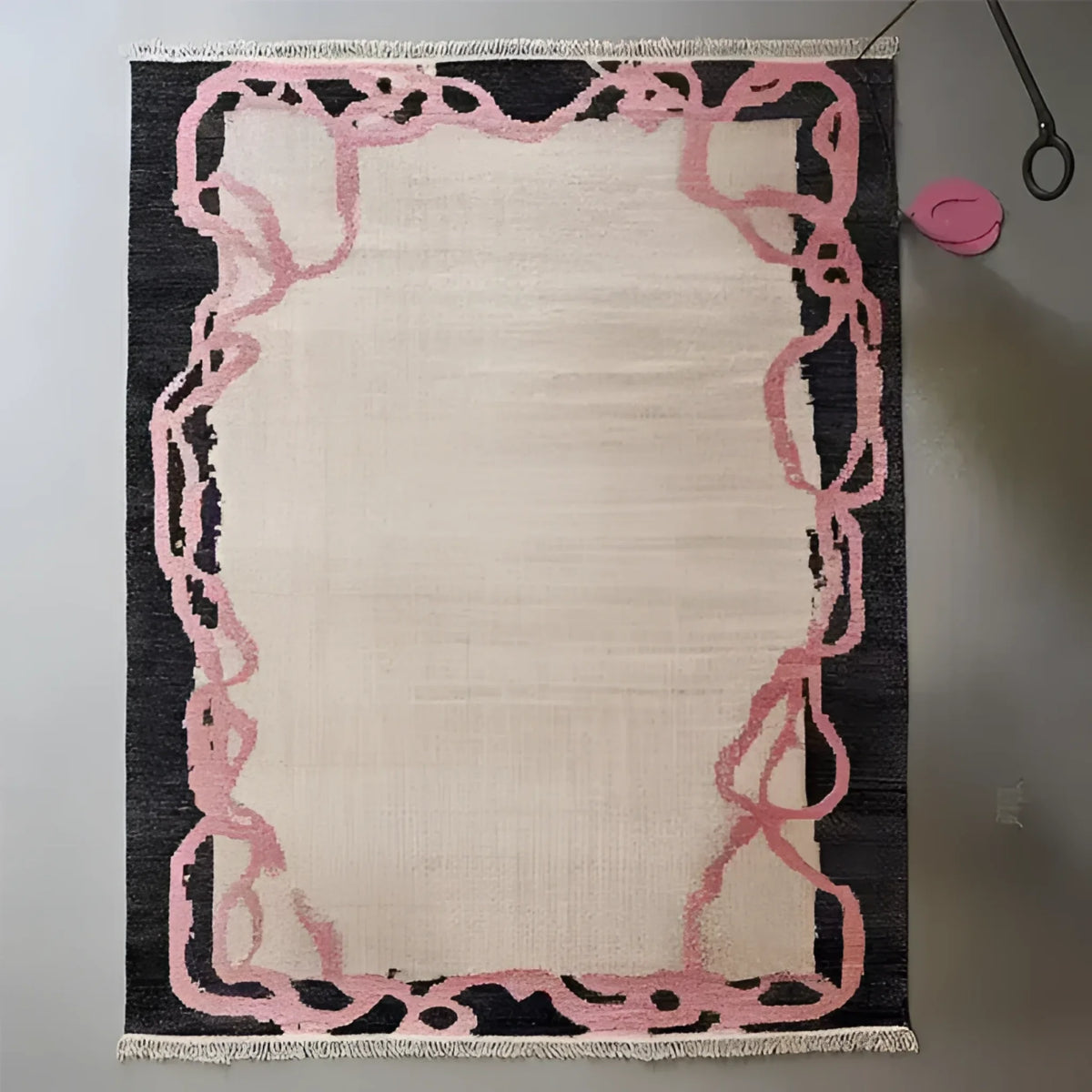 Top view of the Crimson Thread Hand Knotted Wool Rug, showcasing its intricate design with pink abstract patterns on a dark border, ideal for an office or formal dining room setting. This area rug adds a touch of elegance to any dining room or office space.