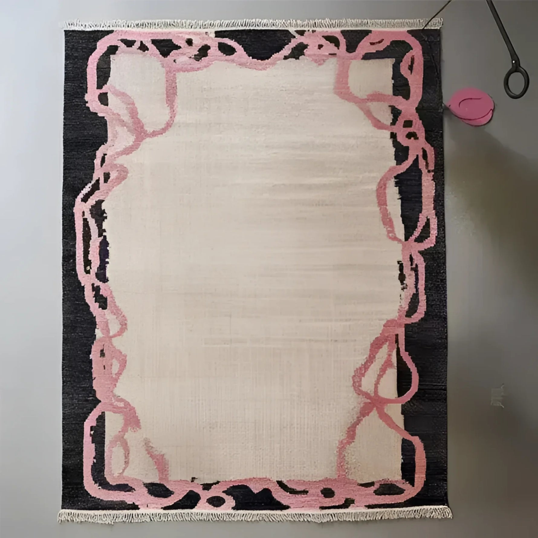 Top view of the Crimson Thread Hand Knotted Wool Rug, showcasing its intricate design with pink abstract patterns on a dark border, ideal for an office or formal dining room setting. This area rug adds a touch of elegance to any dining room or office space.