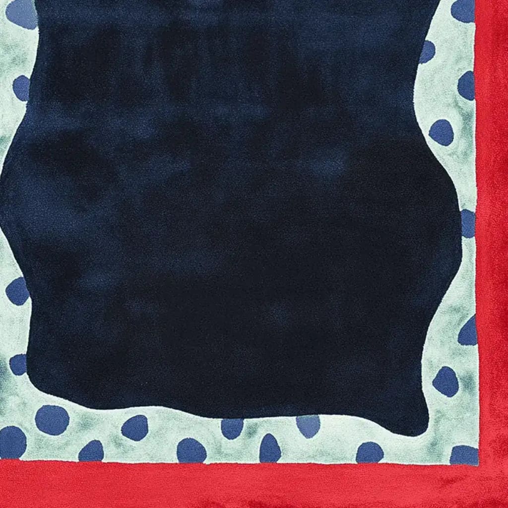 This vibrant area rug features a contemporary design with bold red and black colors, accented by blue pebble-like patterns, perfect for adding a stylish touch to any living room. Made from high-quality wool, this hand-tufted rug offers both durability and a modern aesthetic.