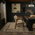 A beautifully styled dining room featuring a large area rug with intricate patterns. This wool rug is perfect for adding warmth and elegance to your living room or dining room. The elegant design complements the chic decor, making it an ideal choice for large area rugs for living room spaces.