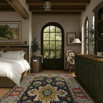 A cozy bedroom featuring a Cultural Threads Hand Tufted Area Rug with an intricate pattern, perfect for enhancing a living room or dining room. This wool rug adds warmth and style beneath a dining table, complementing the rustic decor and large window view.
