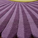 Close-up of a textured purple fabric with a yellow object partially visible.
