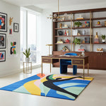 Modern office space with a colorful rug, desk, and bookshelf.