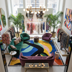 Modern interior design with colorful furniture and abstract rug.