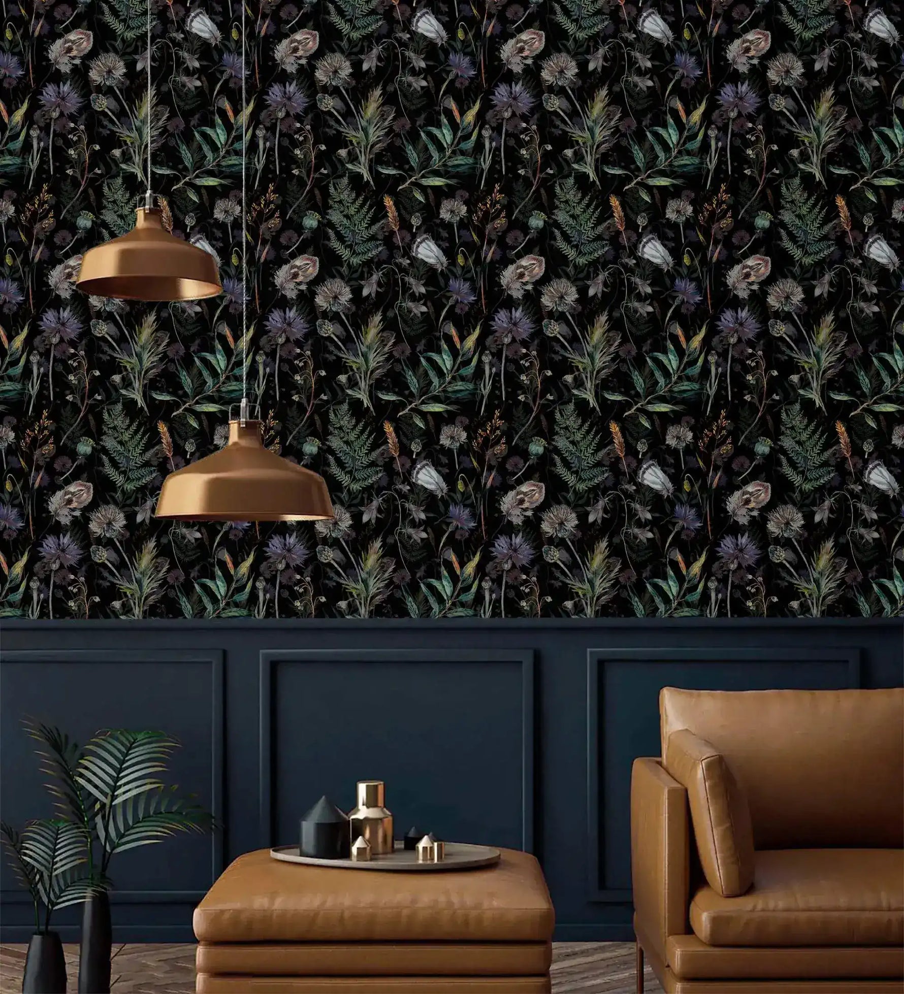 Dark floral fern wallpaper above navy panelling with brass pendant lamps and tan leather seating