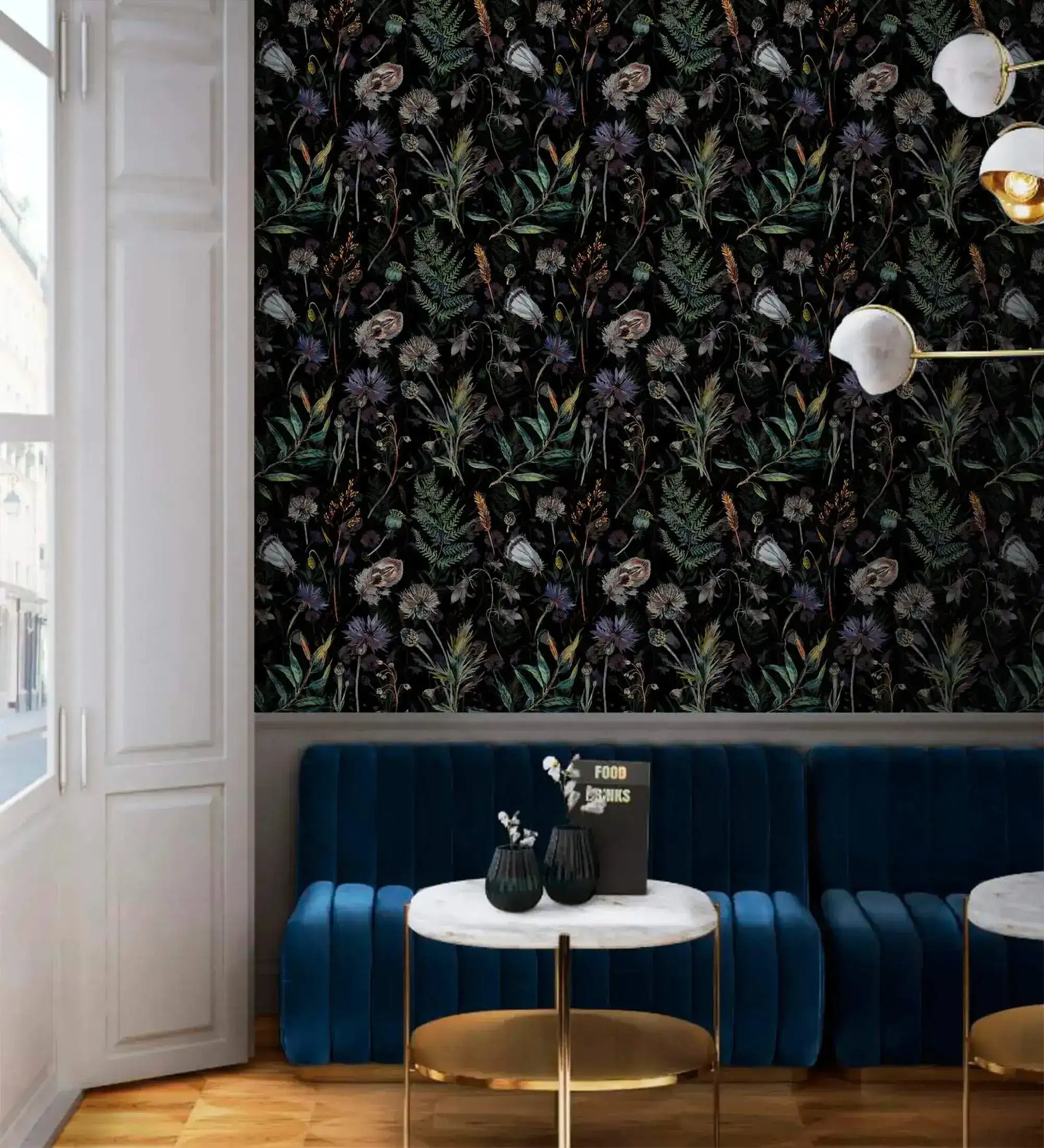 Dark floral fern wallpaper in cafe nook with blue velvet banquette, marble table and brass lamp