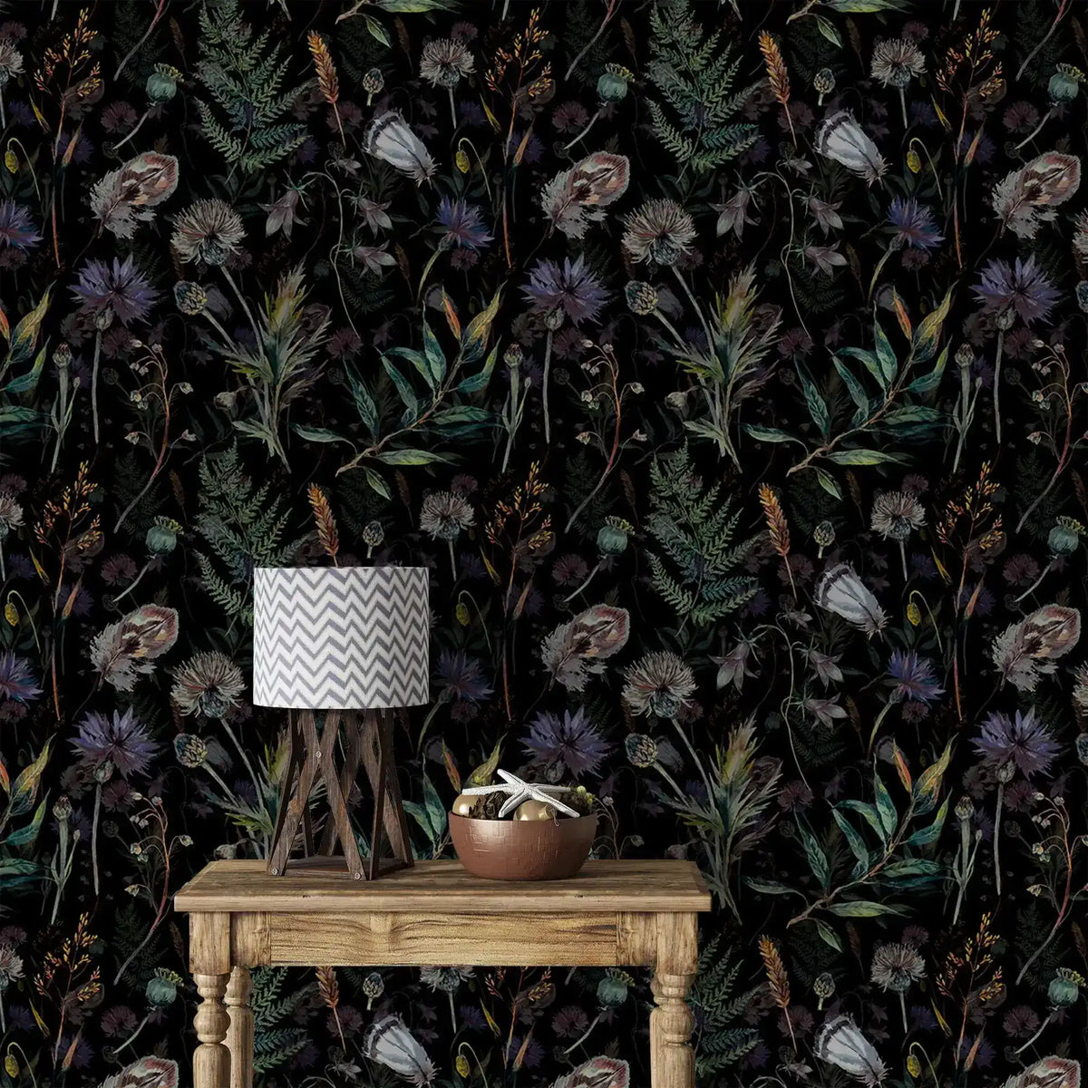 Dark floral wallpaper with thistles, poppies and ferns behind rustic table with chevron lamp and bowl