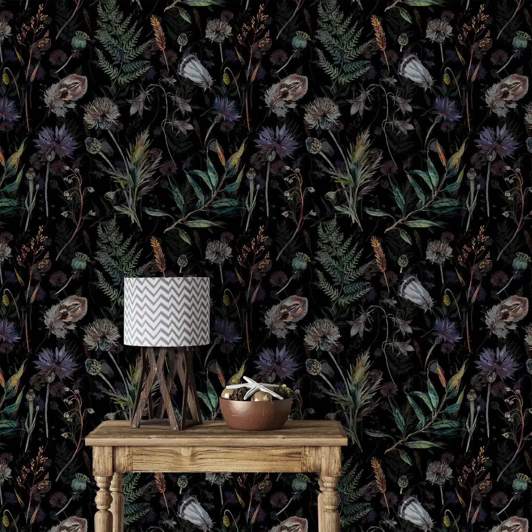 Dark floral wallpaper with thistles, poppies and ferns behind rustic table with chevron lamp and bowl
