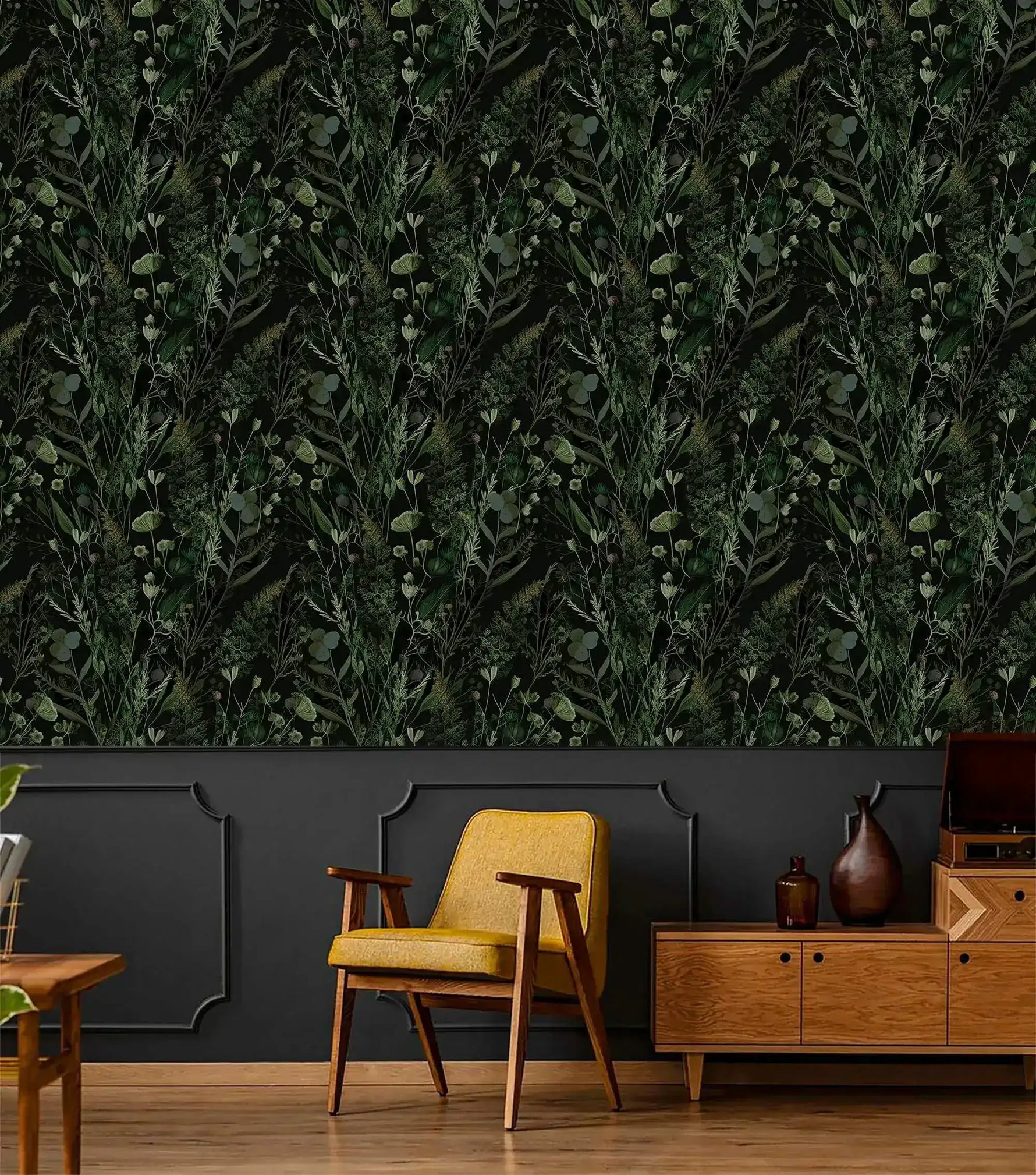 Dark green fern botanical wallpaper above charcoal panelling with yellow midcentury chair and wood sideboard