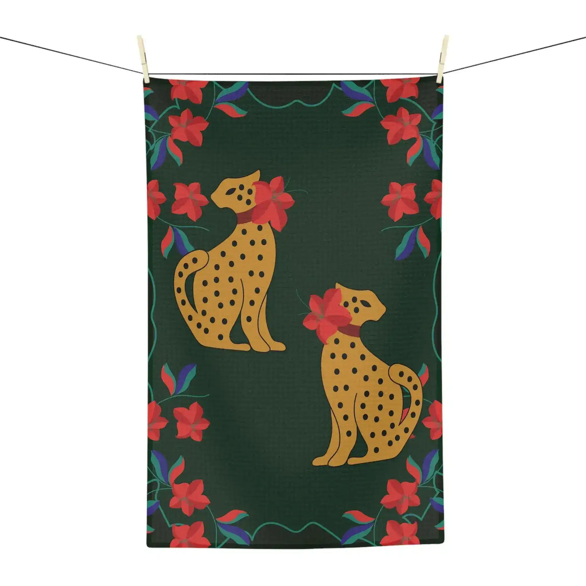 Dark green kitchen towel hung on a line, featuring two seated golden leopards and a red floral border