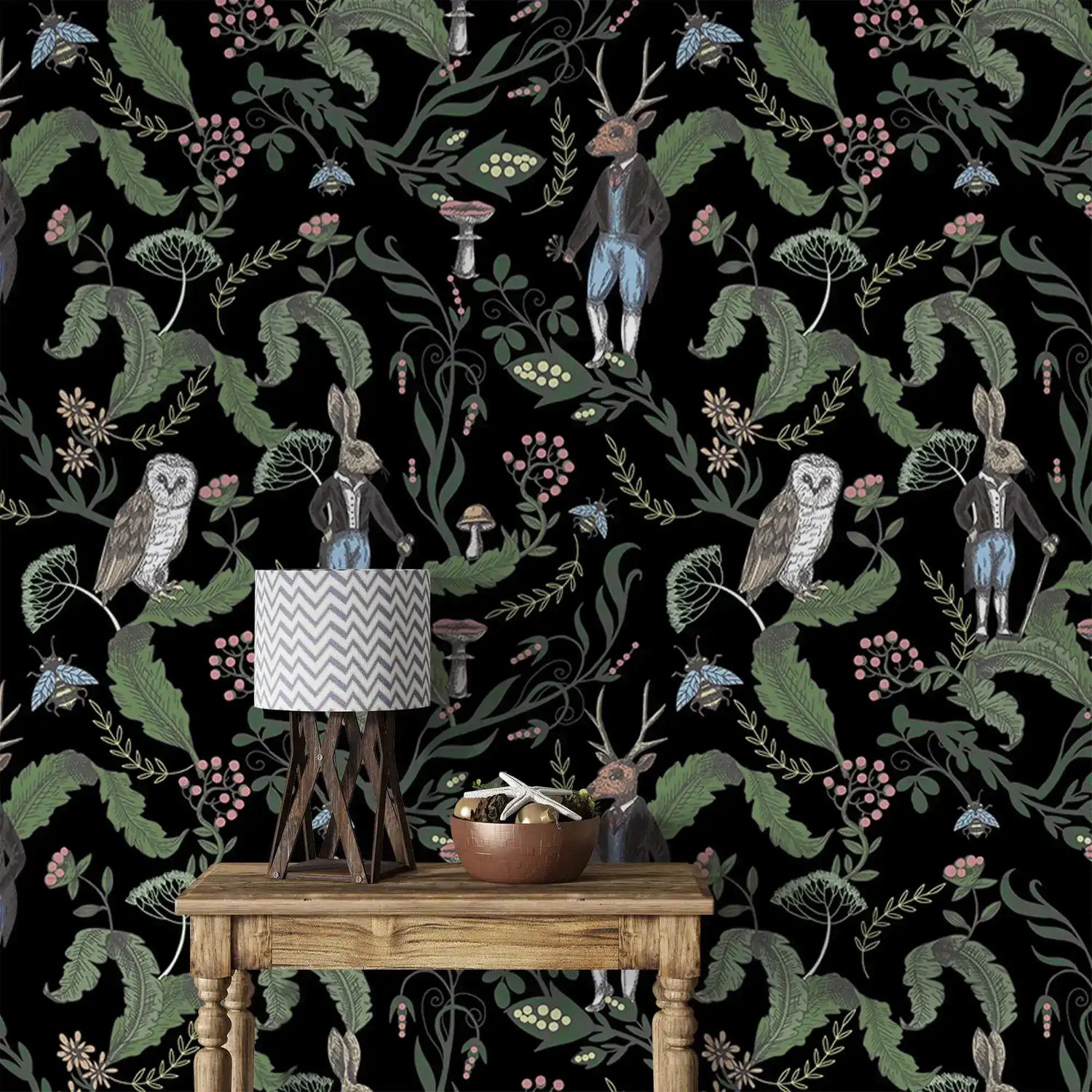 Dark woodland wallpaper detailing owls, a dapper stag and hares with mushrooms and berries on black behind a wood table