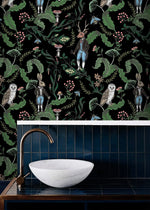 Dark woodland wallpaper with owls, a stag and hares on black above a blue-tiled vanity with a stone basin