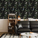 Dark woodland wallpaper with owls and hares on black above wainscoting in a living room with black sofa