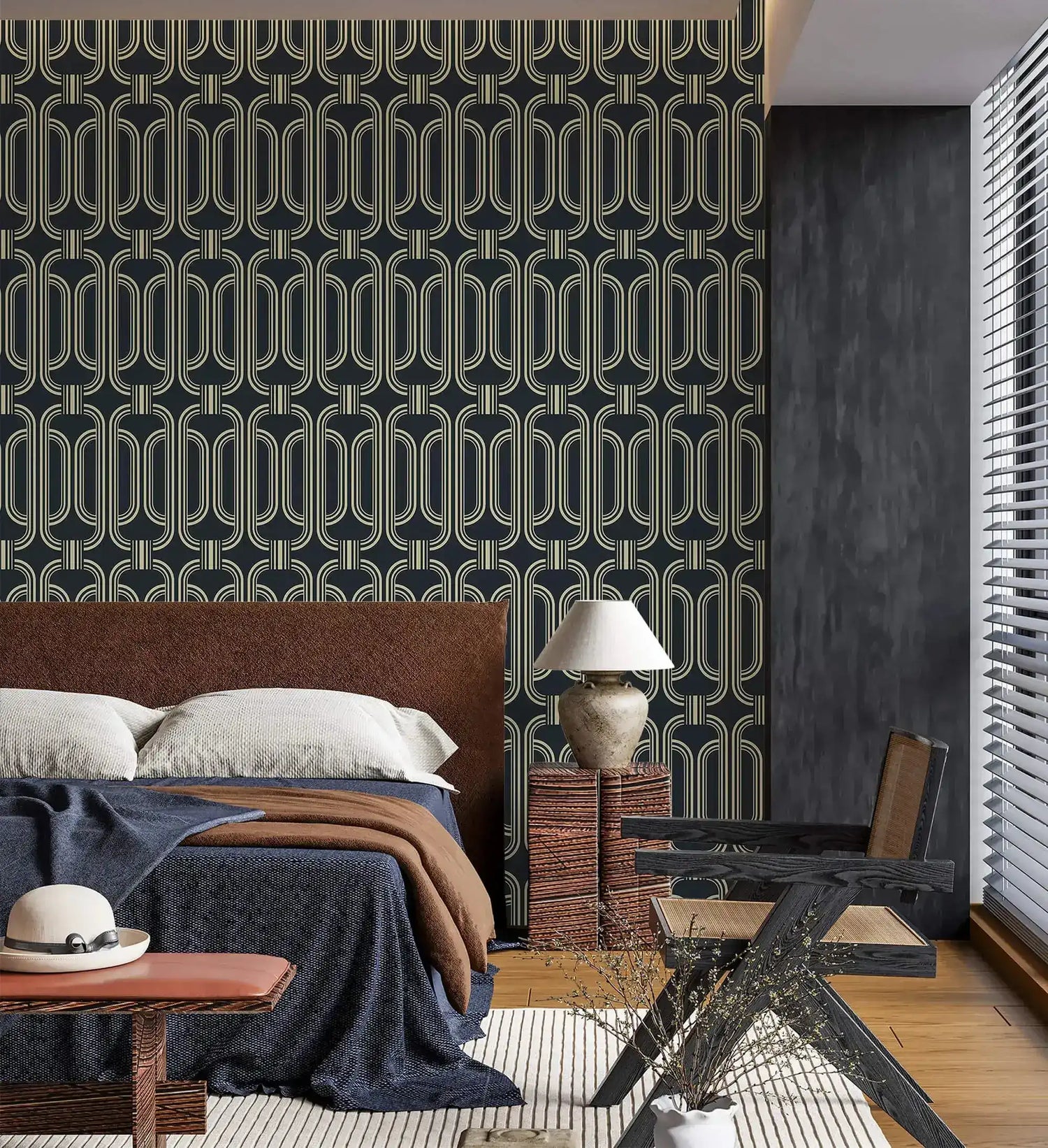 Deco geometric wallpaper with gold linked-oval lines on navy as a bedroom feature wall behind an upholstered bed