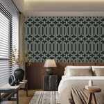 Deco geometric wallpaper with gold linked-oval lines on navy in a bedroom above a wood headboard and neutral bedding