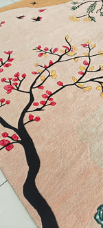 Decorative rug with a tree design featuring red and yellow leaves on a beige background.