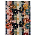 A vibrant hand-tufted wool area rug featuring a colorful floral pattern with bold daisies in shades of pink, orange, blue, and green. The design includes geometric accents, creating a lively and artistic look, perfect for adding a splash of color to any room.
