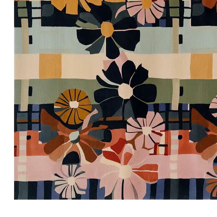 A vibrant, hand-tufted wool area rug featuring a bold floral design with abstract daisies in various colors including navy, pink, orange, and yellow against a striped background.