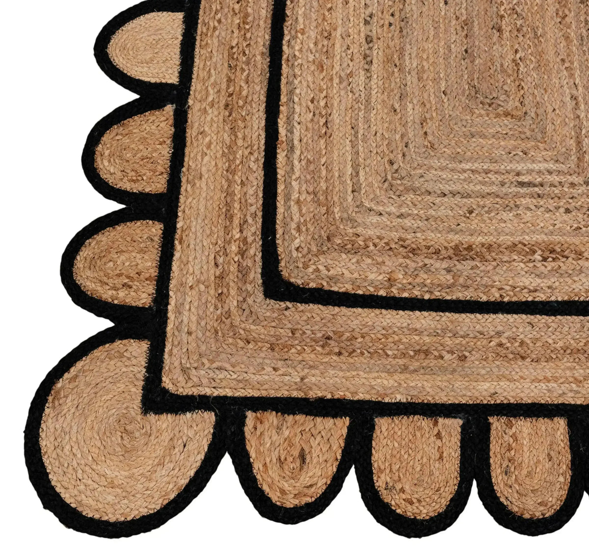 Close-up of a Double Trim Black Scalloped Jute Rug, showcasing its intricate braided design with black scalloped edging. Perfect for adding a natural touch to a living room, this area rug is ideal for those seeking stylish rugs for large living room spaces.