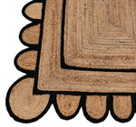 Close-up of a Double Trim Black Scalloped Jute Rug, showcasing its intricate braided design with black scalloped edging. Perfect for adding a natural touch to a living room, this area rug is ideal for those seeking stylish rugs for large living room spaces.