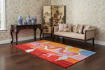 Colorful rug with animal designs in a room with a sofa, table, and decorative screen.