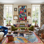 Colorful living room with a green sofa, patterned rug, and abstract art.