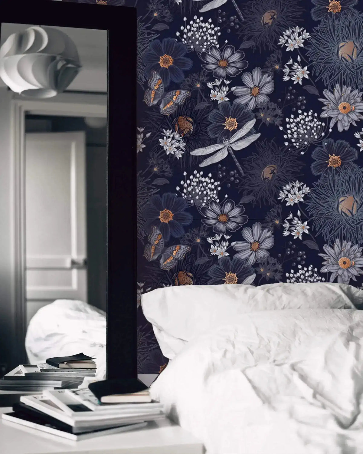 Dragonfly Ballet in Blossoms wallpaper as dark navy bedroom feature wall with dragonflies; white bed linens and mirror