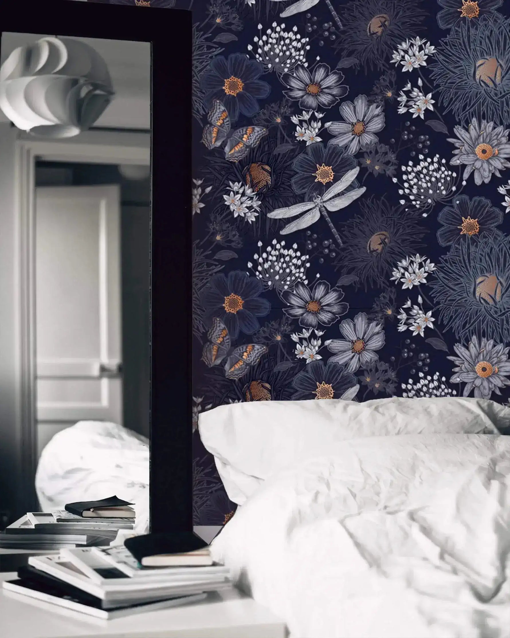 Dragonfly Ballet in Blossoms wallpaper as dark navy bedroom feature wall with dragonflies; white bed linens and mirror