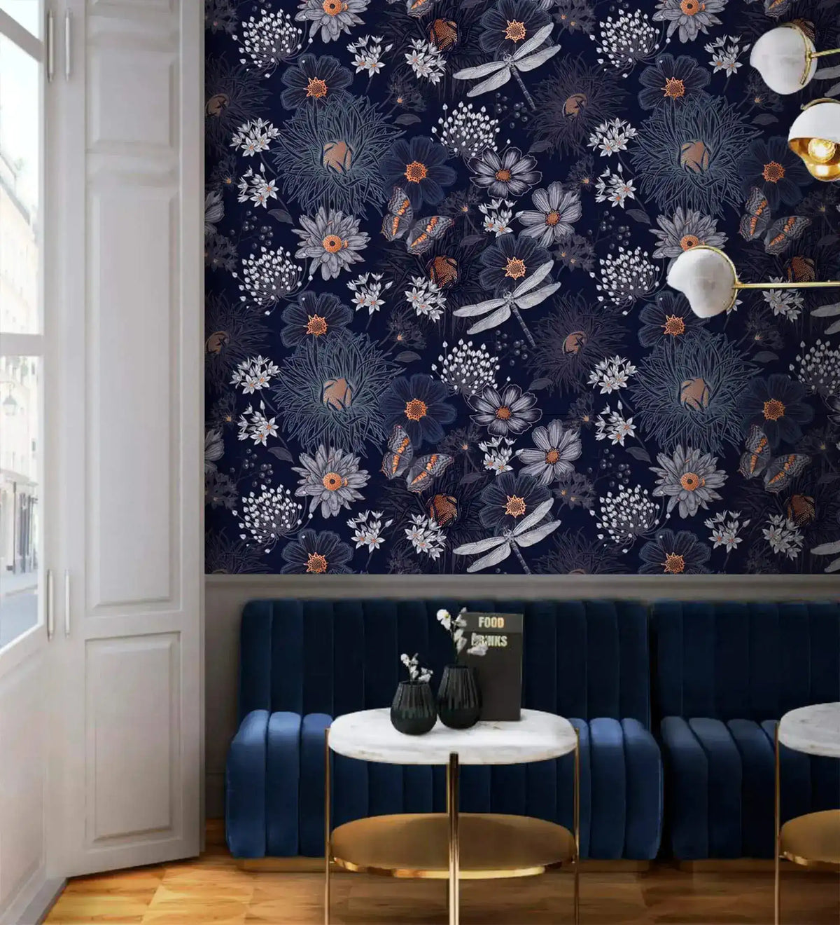 Dragonfly Ballet wallpaper on navy wall with white and rust flowers, dragonflies, butterflies; blue velvet sofa setting