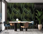 Green and black palm leaves wallpaper in dining room, full feature wall behind round table with blue and tan chairs