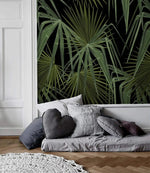 Green and black palm leaves wallpaper panel in white-molded Scandi room with low grey daybed and heart-shaped cushion
