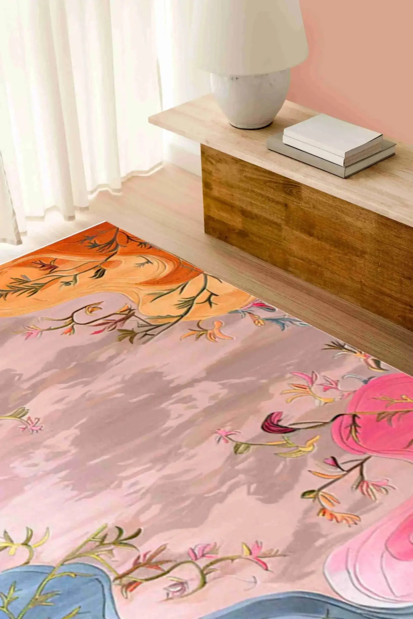 A vibrant Dreamscape Garden hand tufted area rug is beautifully displayed in a cozy bedroom setting. The wool rug features an abstract floral design with pink, orange, and blue hues, making it a perfect choice for adding artistic flair to an office or bedroom. This elegant piece is ideal for those seeking stylish and comfortable bedroom area rugs.