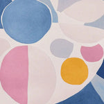 A vibrant Dreamscape Patch Play hand-tufted area rug showcasing a contemporary design. This wool rug features an abstract pattern with large colorful circles in shades of blue, pink, yellow, and white, making it an ideal choice for large living room spaces. Perfect for adding a pop of color and modern flair to any living room area.