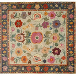 Colorful Dreamy Floral Hand Knotted Area Rug with intricate floral patterns in vibrant hues of red, purple, yellow, and green on a beige background. The border showcases a rich tapestry of floral designs, adding elegance and charm to any room.