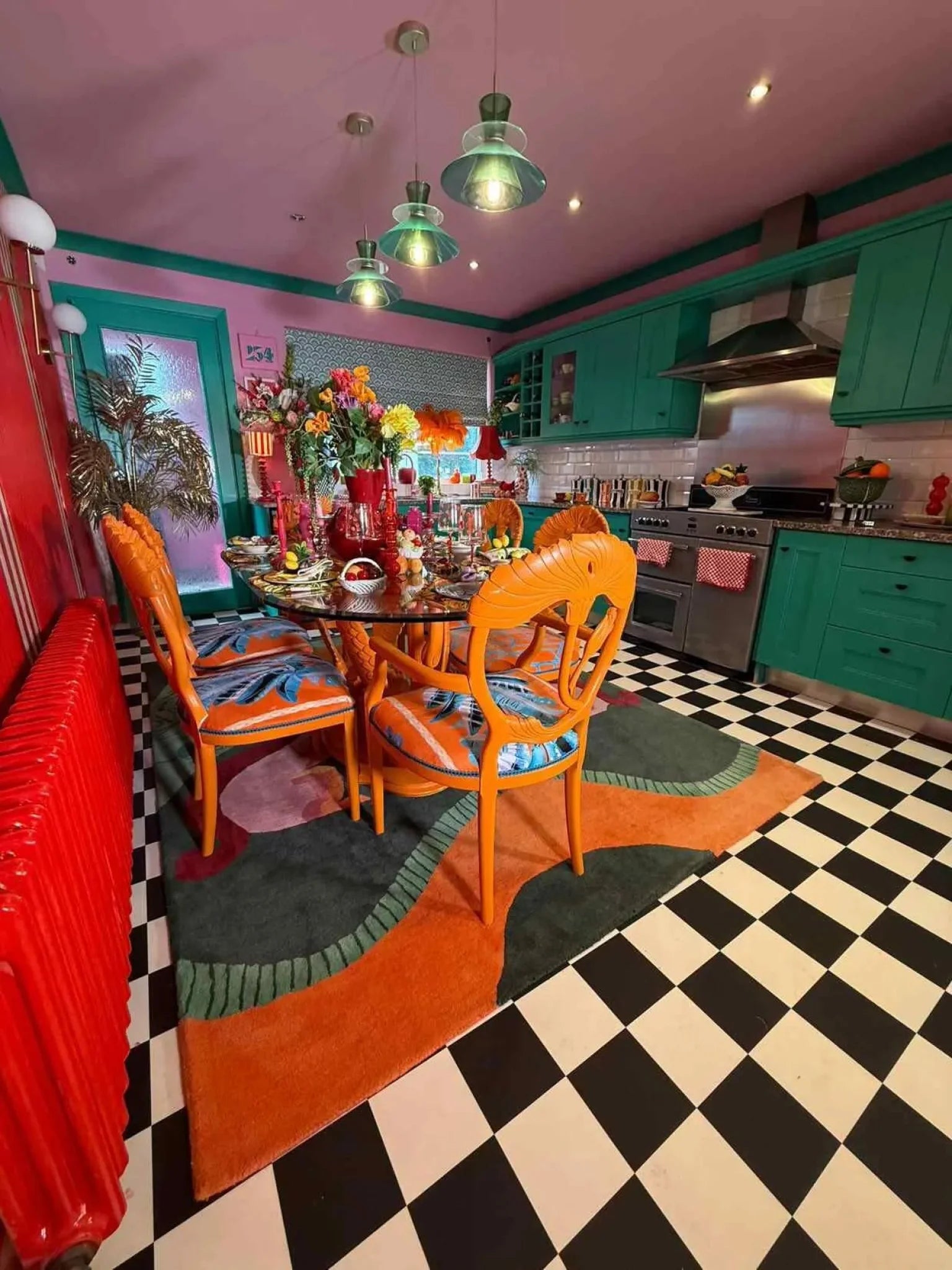 A vibrant, contemporary area rug featuring bold abstract designs in a colorful dining room. The Duo Tails Hand Tufted Rug adds a splash of color with its intricate patterns, making it an ideal addition to a modern bedroom or office space. Perfect for those seeking a unique wool rug that enhances any room's aesthetic.