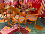 A vibrant Duo Tails Hand Tufted Area Rug adding a contemporary flair to a dining room with bold orange chairs and a glass table. The wool rug features an abstract design, perfect for modern bedrooms or offices, making it an ideal choice for office rugs.