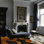 Elegant living room featuring a striking area rug with abstract orange and black patterns. The wool rug adds a vibrant touch to the sophisticated space, complementing the stylish chaise lounge and classic fireplace. Perfect for enhancing both living and dining rooms.