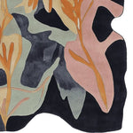 A contemporary hand-tufted wool area rug with abstract botanical shapes in orange, pink, and blue tones, perfect for large living room spaces.