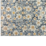 Elegant hand-tufted wool area rug featuring a serene floral design with delicate white and yellow blossoms on a soft blue background, perfect for adding a touch of eastern tranquility to any room.