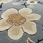 Floral patterned rug with beige flowers on a gray background