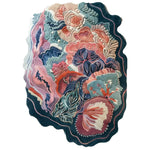Eclectic Garden Hand Tufted Wool Rug featuring a vibrant, abstract floral pattern in shades of blue, pink, and orange. The rug showcases intricate details and a unique, irregular shape, perfect for adding a touch of artistic flair to any room. This area rug is crafted from high-quality wool, ensuring both durability and comfort.